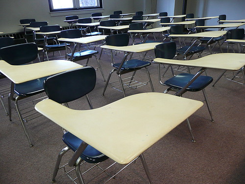 Classroom. Attribution: <p style="font-size: 0.9rem;font-style: italic;"><a href="http://www.flickr.com/photos/90718153@N00/4189931447">"Lined up in rows"</a><span>by <a href="http://www.flickr.com/photos/90718153@N00">Lorianne DiSabato</a></span> is licensed under <a href="https://creativecommons.org/licenses/by-nc-nd/2.0/?ref=ccsearch&atype=html" style="margin-right: 5px;">CC BY-NC-ND 2.0</a><a href="https://creativecommons.org/licenses/by-nc-nd/2.0/?ref=ccsearch&atype=html" target="_blank" rel="noopener noreferrer" style="display: inline-block;white-space: none;opacity: .7;margin-top: 2px;margin-left: 3px;height: 22px !important;"><img style="height: inherit;margin-right: 3px;display: inline-block;" src="https://search.creativecommons.org/static/img/cc_icon.svg" /><img style="height: inherit;margin-right: 3px;display: inline-block;" src="https://search.creativecommons.org/static/img/cc-by_icon.svg" /><img style="height: inherit;margin-right: 3px;display: inline-block;" src="https://search.creativecommons.org/static/img/cc-nc_icon.svg" /><img style="height: inherit;margin-right: 3px;display: inline-block;" src="https://search.creativecommons.org/static/img/cc-nd_icon.svg" /></a></p>