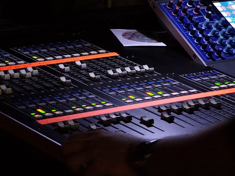 Close-up photo of sound mixer, left-hand side view, dark lighting. 